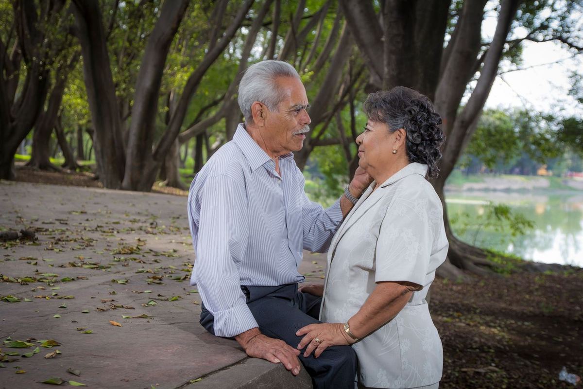 An older couple sharing a tender moment under the trees