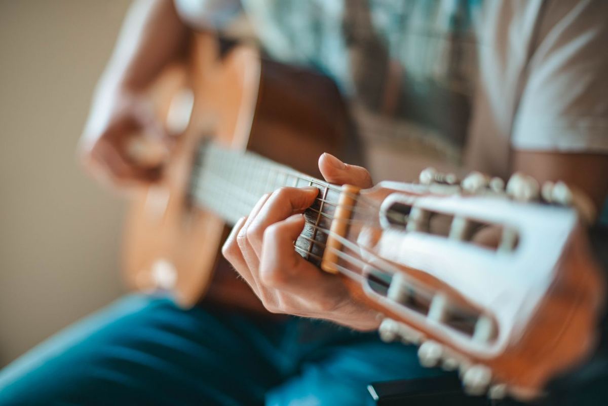 Hands playing an acoustic guitar