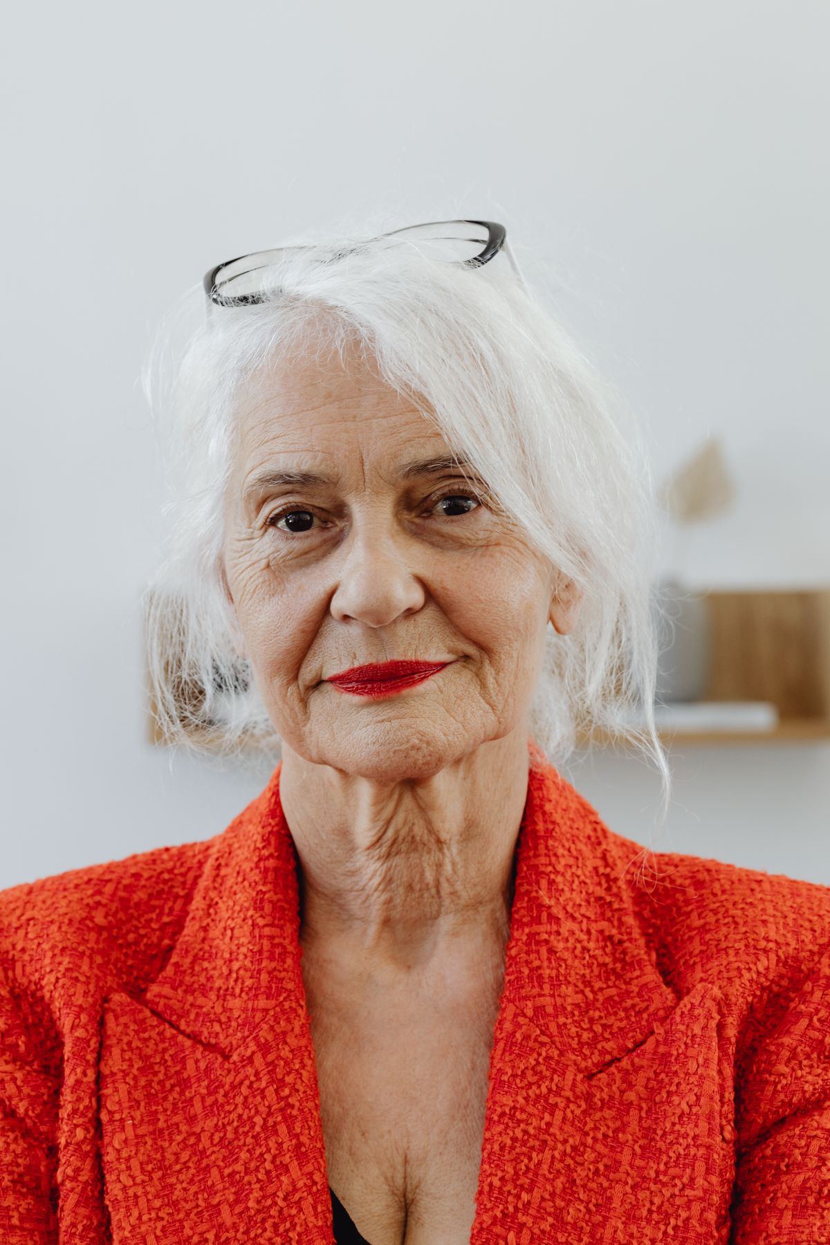 An older woman in a red blazer smiling